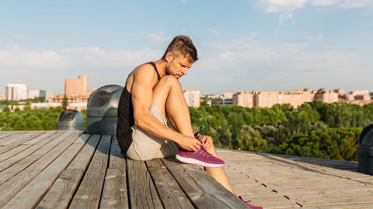 male runner tying up shoes header