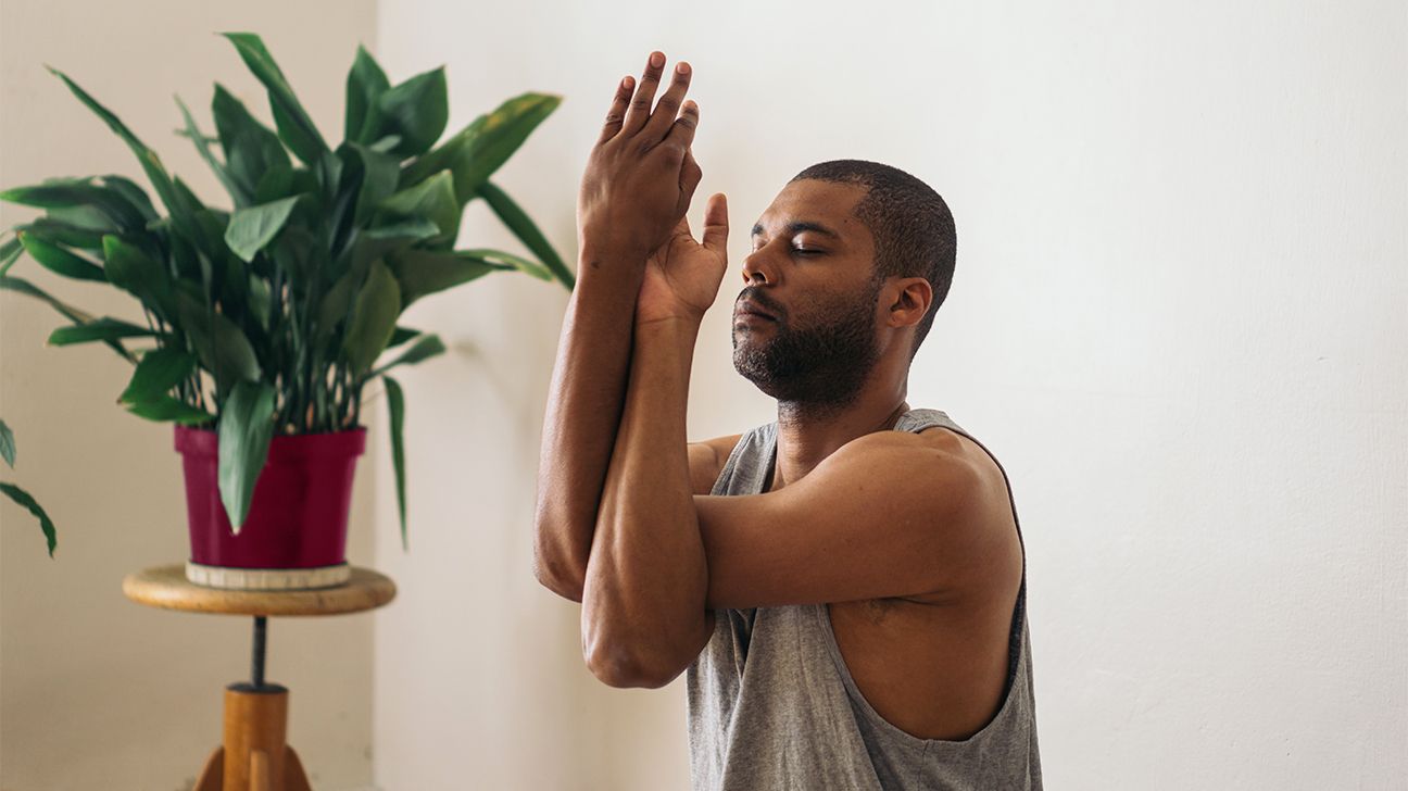 Adult man doing yoga at home