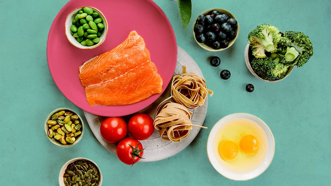 Salmon on a pink plate surrounded by other nutritious ingredients